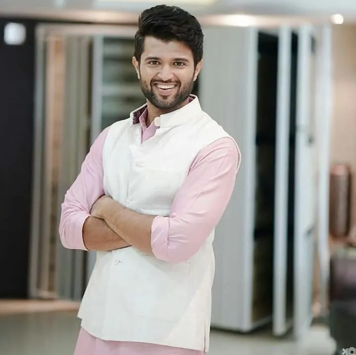 Smiling Vijay Devarakonda in pink kurta with white nehru jacket posing for camera Smiling Vijay Devarakonda in pink kurta with white nehru jacket posing for camera - handsome actors south indian industry
