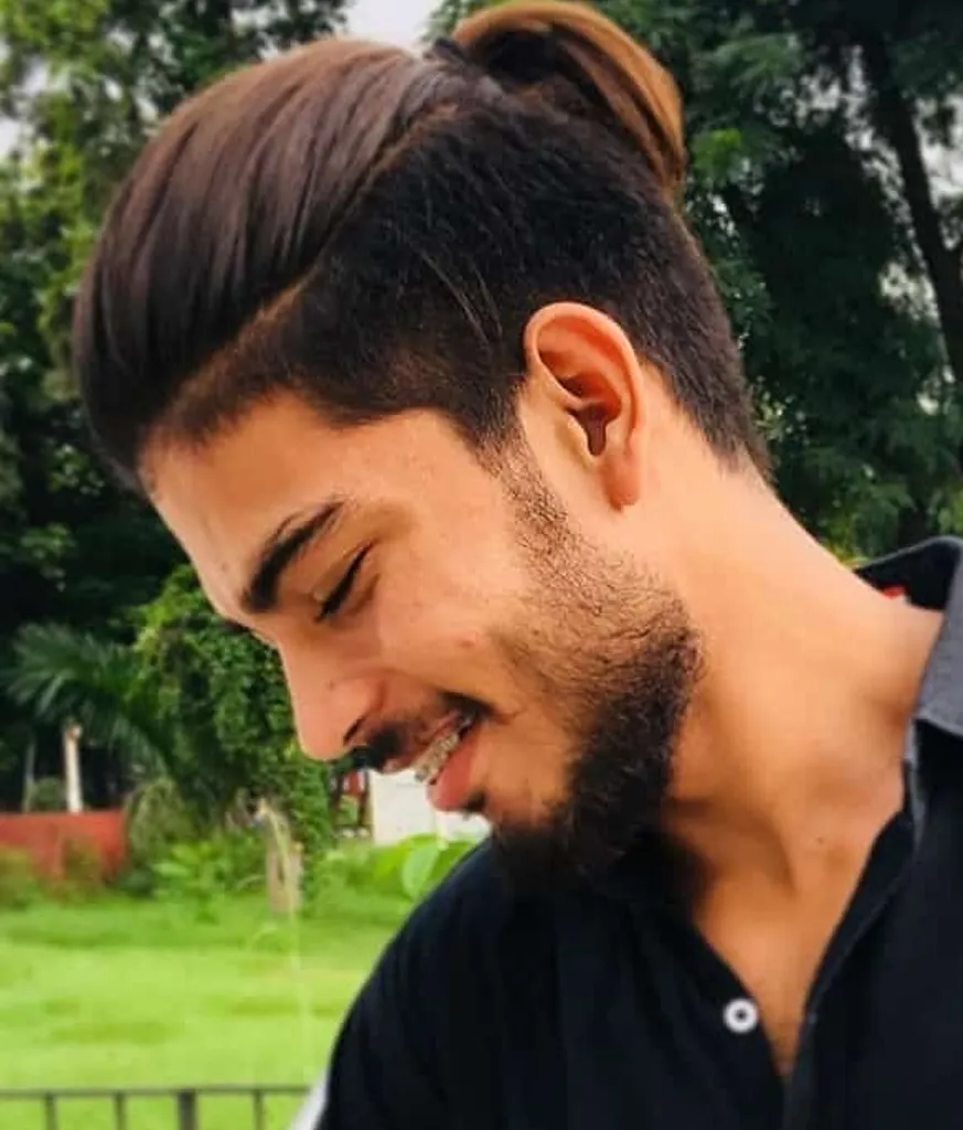 Smiling boy in black shirt and Ponytail hairstyle Smiling boy in black shirt and Ponytail hairstyle - best haircut for Indian boy
