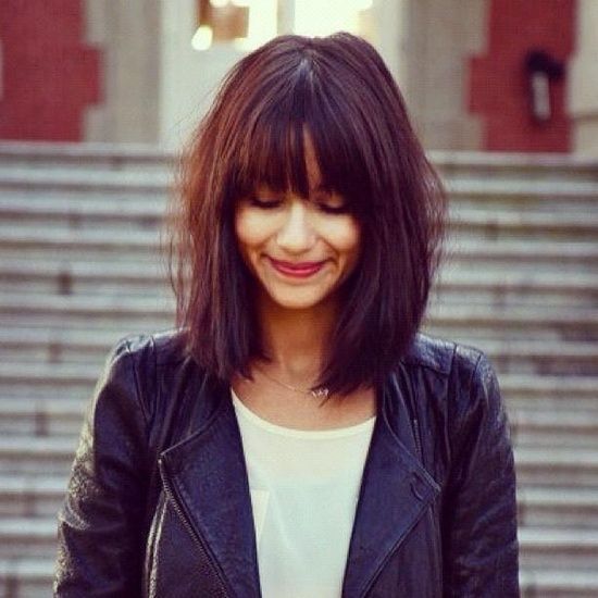 A woman in black leather jacket with white top and Bold Fringe with Blunt Cut hairstyle -  hairstyles for girls with medium hair