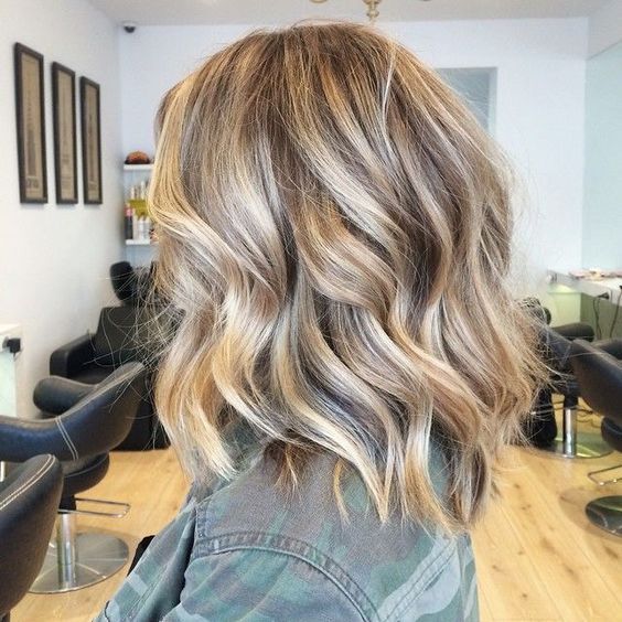A woman in blur denim shirt and  Even Balayage hairstyles - haircut for medium hair girl