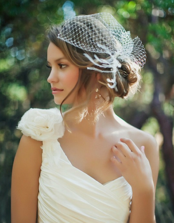 A girl in one shoulder white gown posing for camera and showing her Traditional With Veil - Wedding hairstyles
