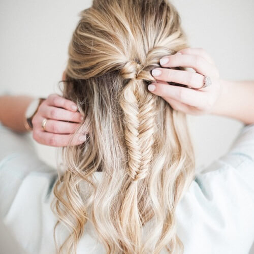 A woman in white shirt and pulled fish tail hairstyle - hairstyles for girls with medium hair