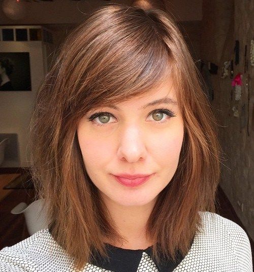 A woman in grey and black dress and sweeping side hairstyle - hairstyles for girls with medium hair