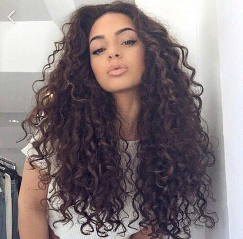 Woman in white t-shirt posing for a selfie and showing her Tight Curls Long Hair - best hairstyles for long hair female