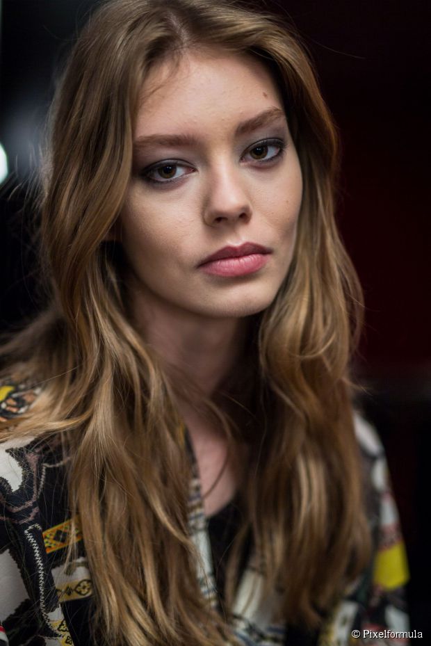 Woman in multi color shirt and Tousled Layer Long Hair - hairstyle for long hair on jeans top