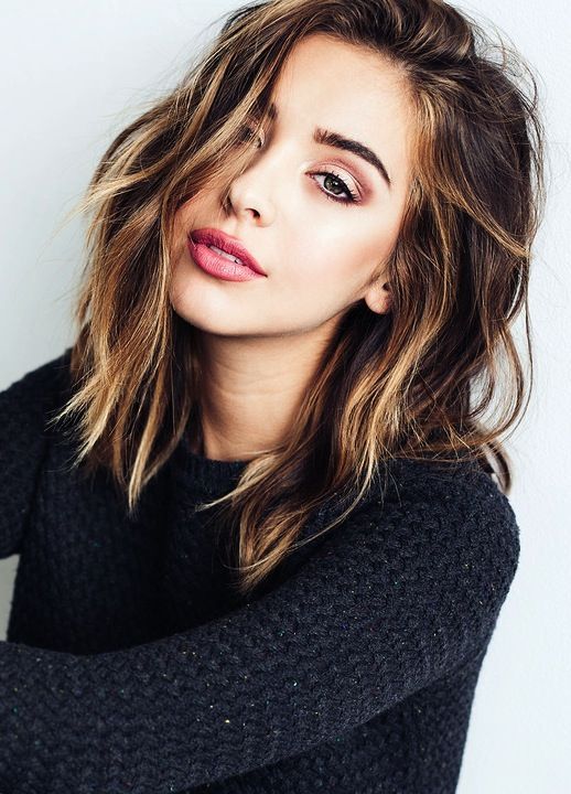 A girl in black pullover and pink lipstick showing her Wavy bob with highlights - haircut Teenage Girls