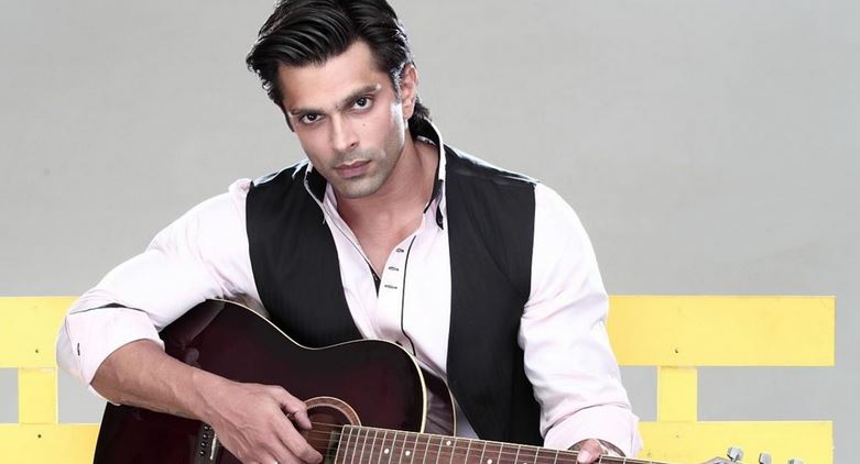 Karan Singh Grover mavi yarım ceketli ve beyaz gömlekli gitar çalıyor - En Yakışıklı Hintli TV Aktörleri