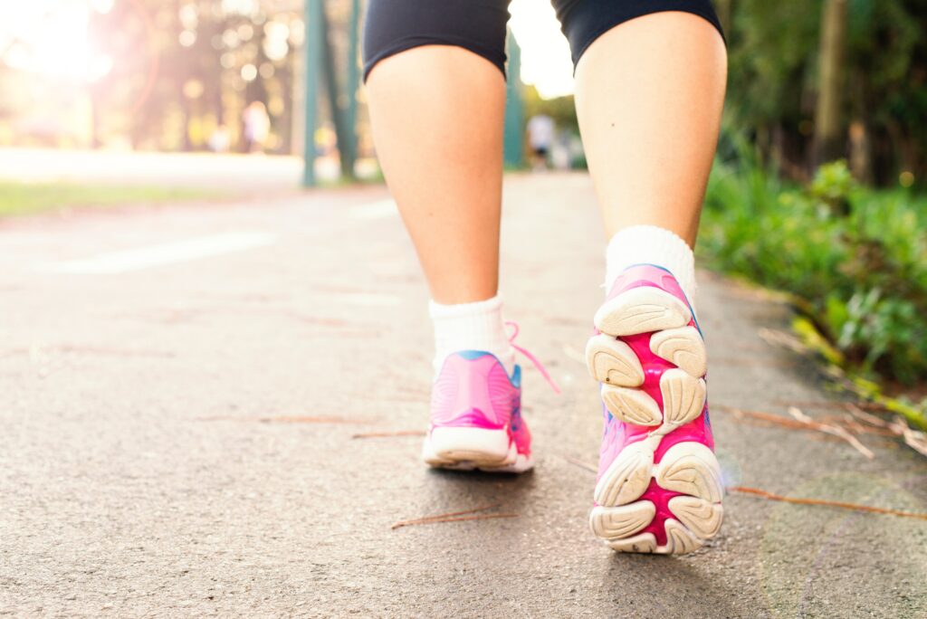 A girl is walking wearing pink shoes