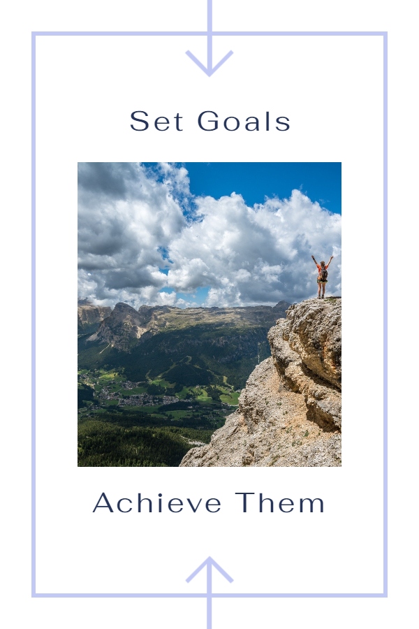 Set realistic goals - a woman is standing like an achiever raising hands on the mountain