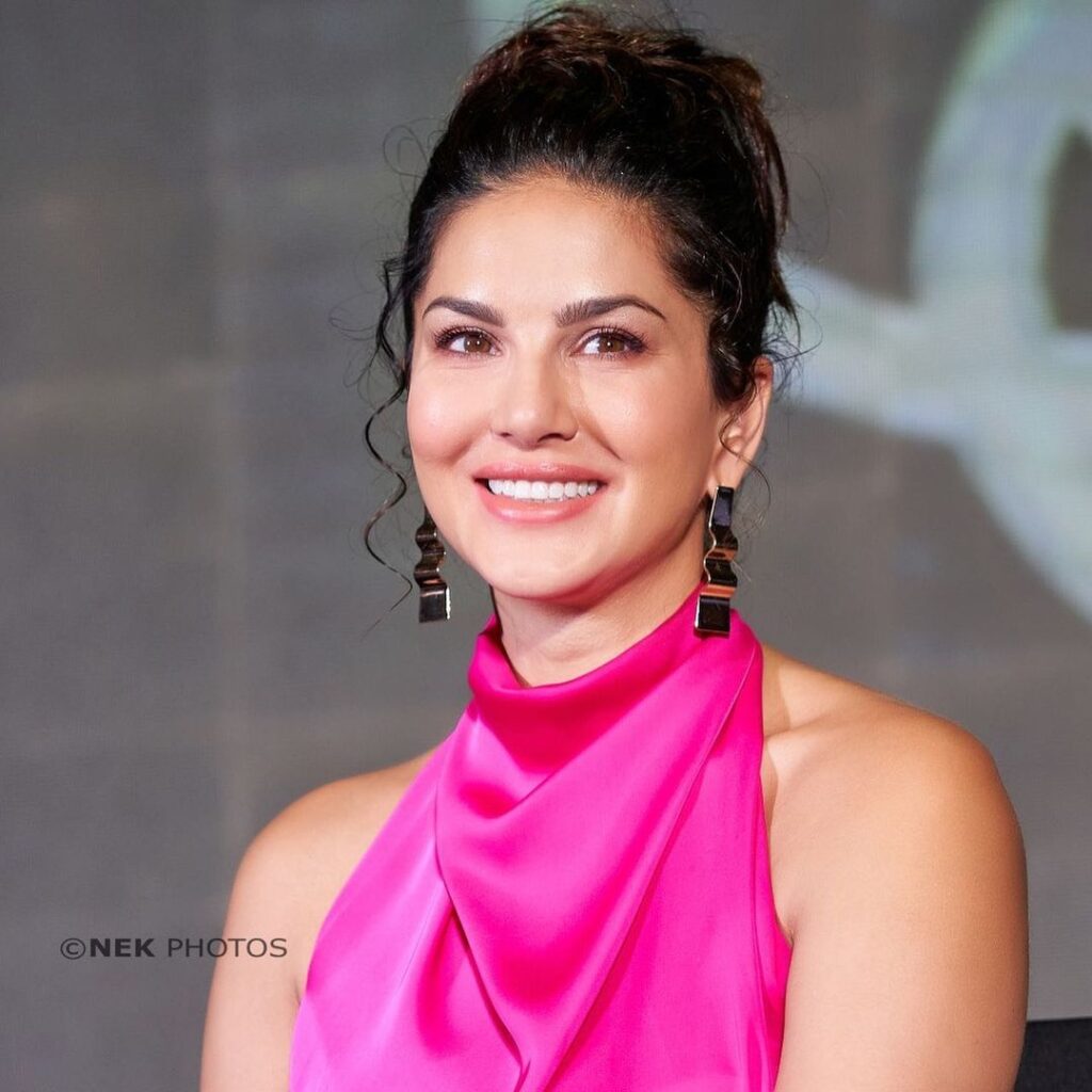 Sunny Leone smiling in pink dress and showing her messy bun - Sunny Leone Hairstyles
