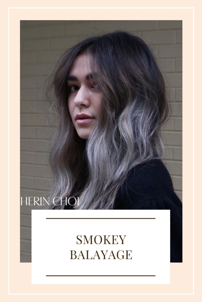 A pretty woman is giving a side pose and showing her Smokey Balayage - hair color highlights