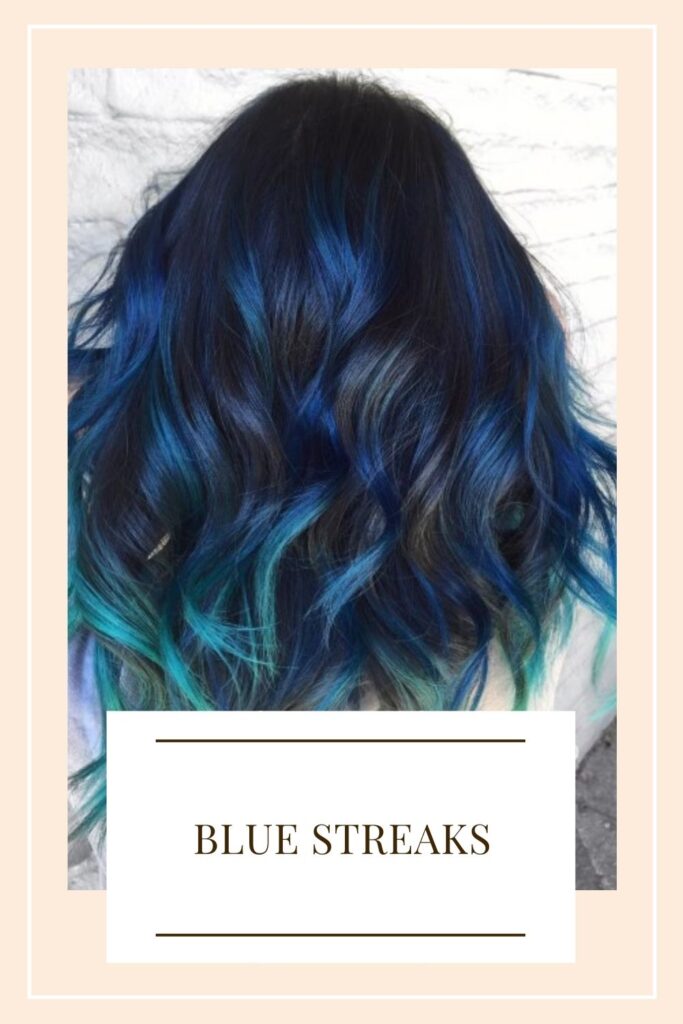 A women is showing her long hair with Blue Streaks - hair color for women 2021