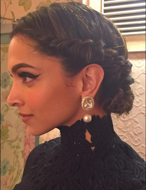 Deepika in all black look with braided bun giving side pose - deepika padukone different hairstyles