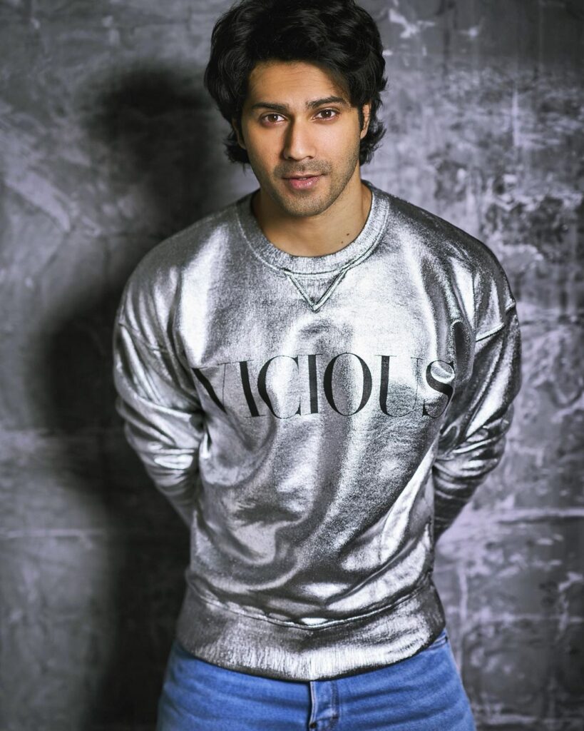 Varun Dhawan in shiny grey t-shirt posing for camera - male actors in India