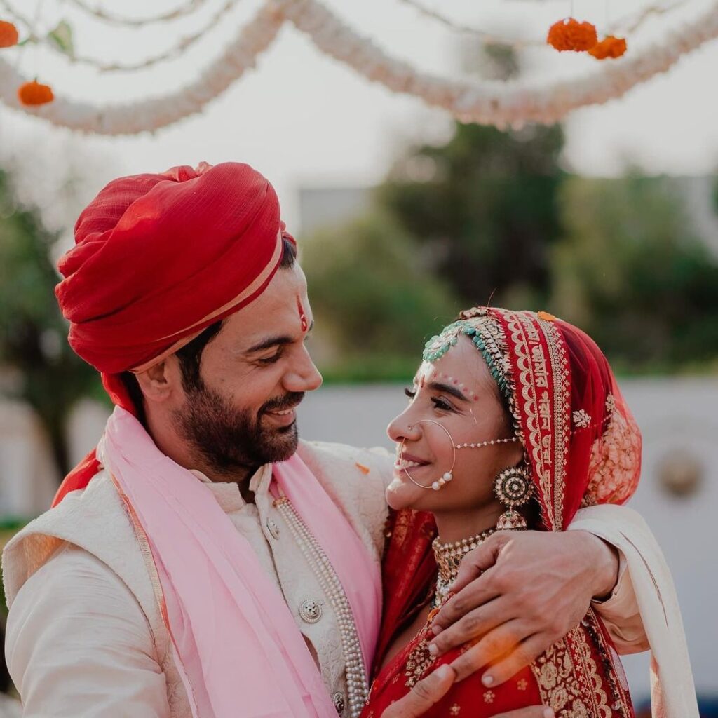 Rajkumar Rao and Patralekha smiling and looking at each other in their wedding outfit - celebrity marriage 2021
