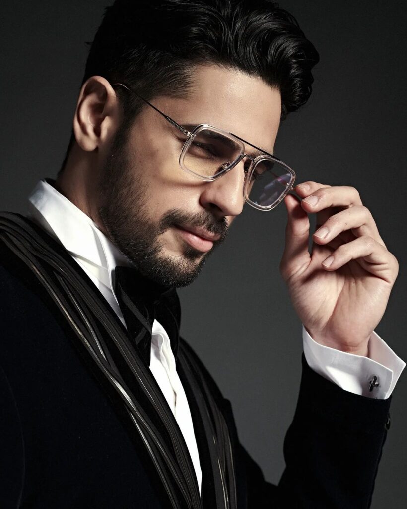 in black coat and white shirt Sidharth Malhotra posing with goggles - bollywood handsome actors