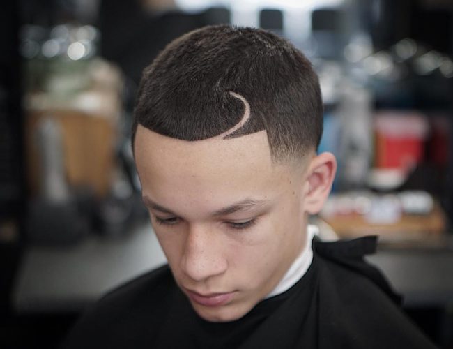 A boy is sitting and showing his Curved Part + Line Up + High Taper Fade - hairstyles for boys 2021