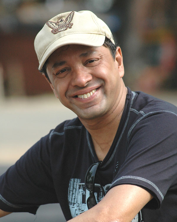Sridhar Rangayan is smiling and sitting in grey t-shirt - lesbian celebrities Bollywood