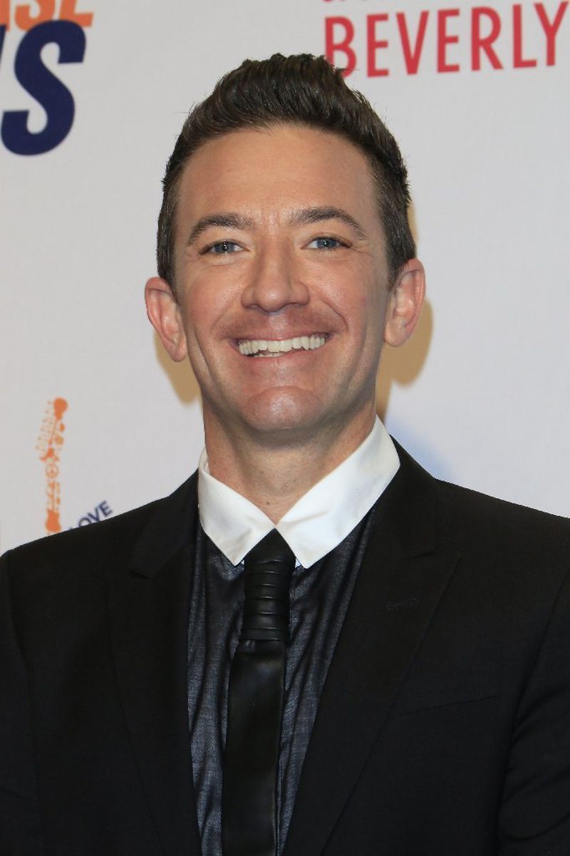 Smiling David Faustino in black suit posing for camera - Short Male Actors