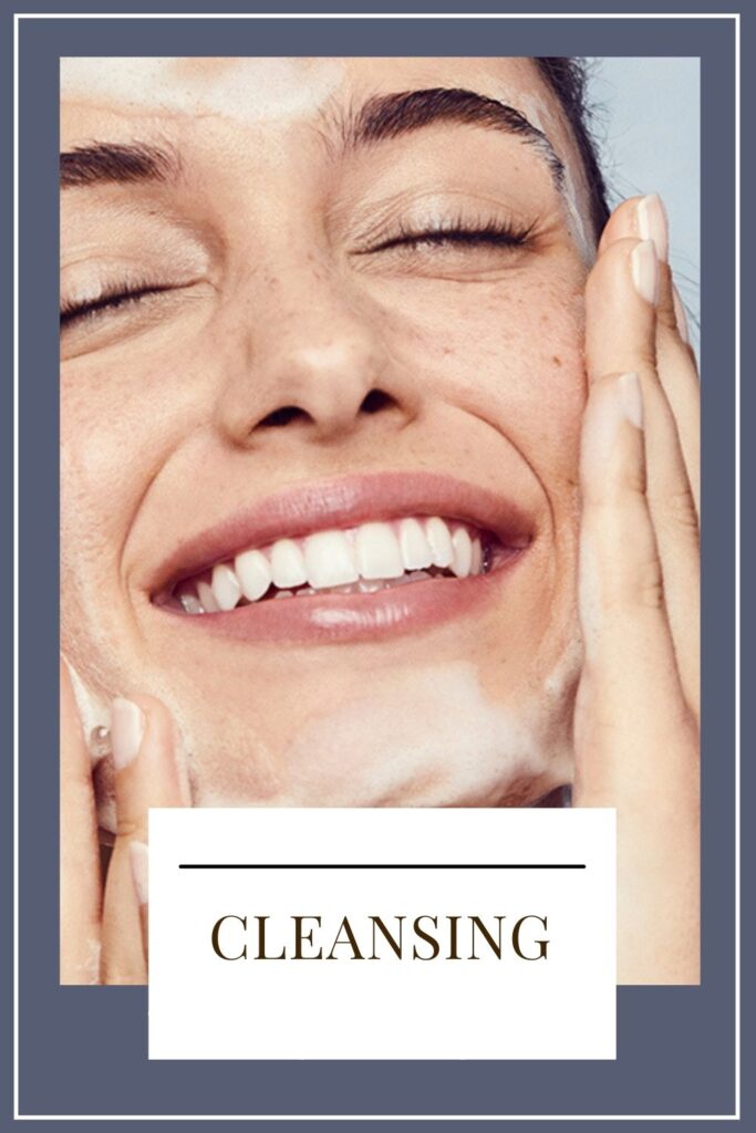 A smiling girl is cleansing her face - daily skin care routine