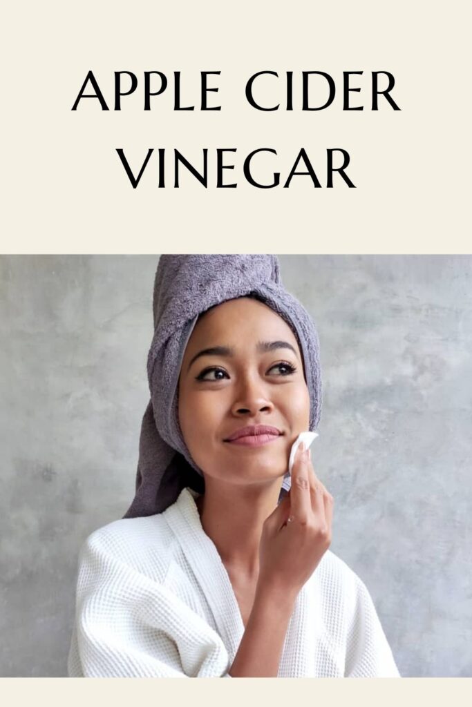 A girl in white bath robe applying apple cider vinegar on her face with cotton pad A girl in white bath robe applying apple cider vinegar on her face with cotton pad - - skincare routine for acne prone skin