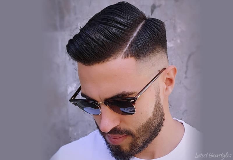 A boy in white t-shirt and goggles showing his hard part haircut - men's hairstyles 