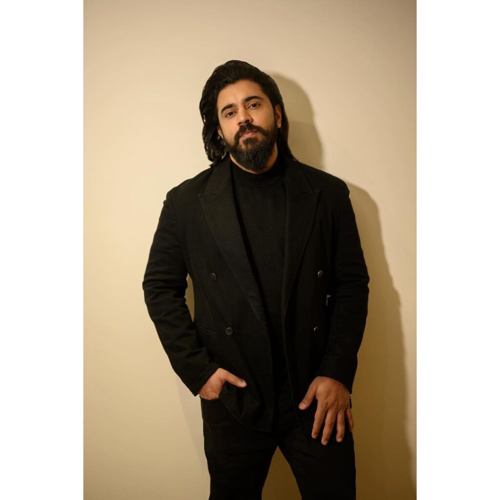 Nivin Pauly in an all black look posing for the camera - handsome South Indian actors
