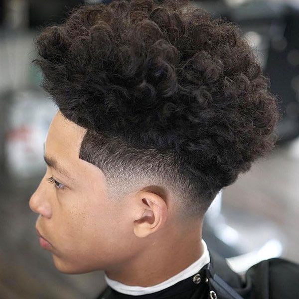 A boy showing his extreme curly hair with blowout with taper fade hairstyle - short hairstyle for boys