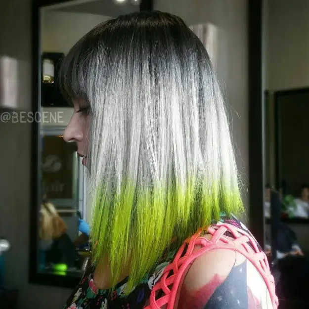 A girl in multi color cut sleeves top showing the side view of her Bright Green Ombre Hair color - hair color 2022 