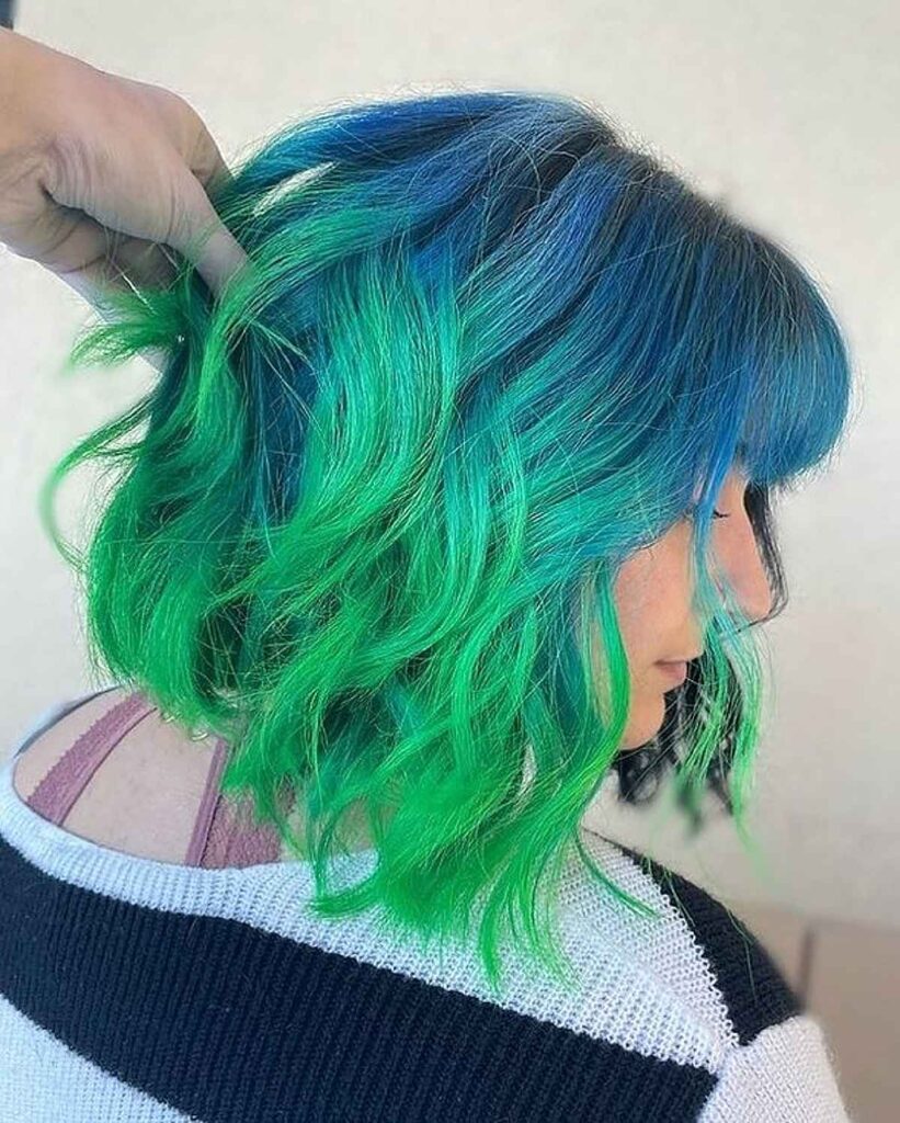 A girl in black and white pullover showing her Blue-Green Hair Color - green hair color ideas for women