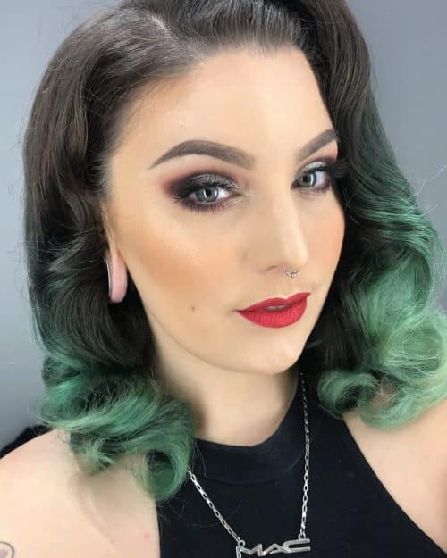 A girl in black cut sleeves top with bright red lipstick posing for camera and showing her Black Hair with green Teal Dip Dye - green hair color for women