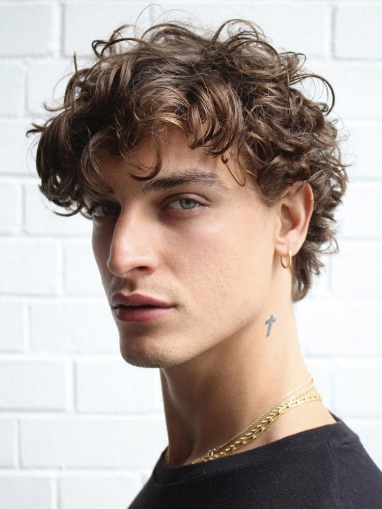 A boy in black round neck t-shirt with gold chain showing the side view of his Long and Lazy Permed Curls hairstyle - men's haircut