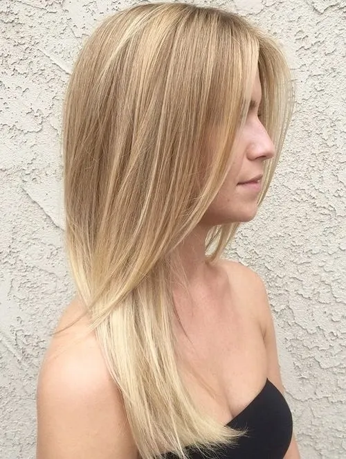 A girl in black tube top showing the side view of her straight Sandy Blonde Layers - latest hair color for women