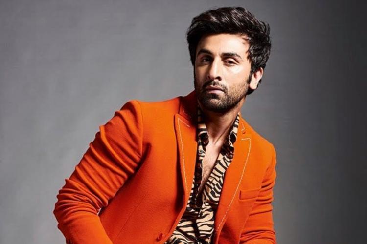 Ranbir Kapoor in orange coat with printed shirt posing for camera - latest hairstyles of bollywood actors 
