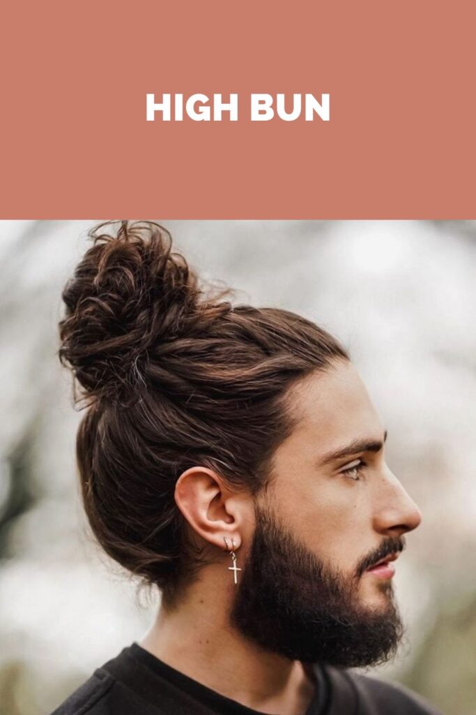 Ein Mann im schwarzen T-Shirt, das seine High Bun-Frisur zeigt Ein Mann im schwarzen T-Shirt, das seine Hochbuntfrisur zeigt - Frisuren für Männer mit langem Haar