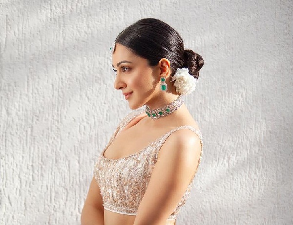 A girl in silver embraided blouse with a necklace  showing the side view of her Sleek Tight Bun - Bridal hairstyles