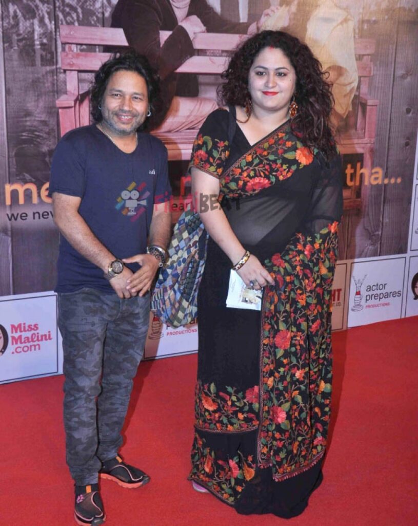 Kailash kher in blue t-shirt with wife in black embroided saree posing for camera - famous couple singers India 