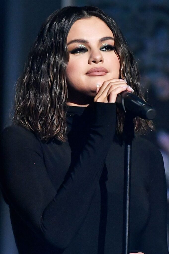 Selena Gomez in black high neck dress posing for camera and showing her Wet Waves - selena gomez age