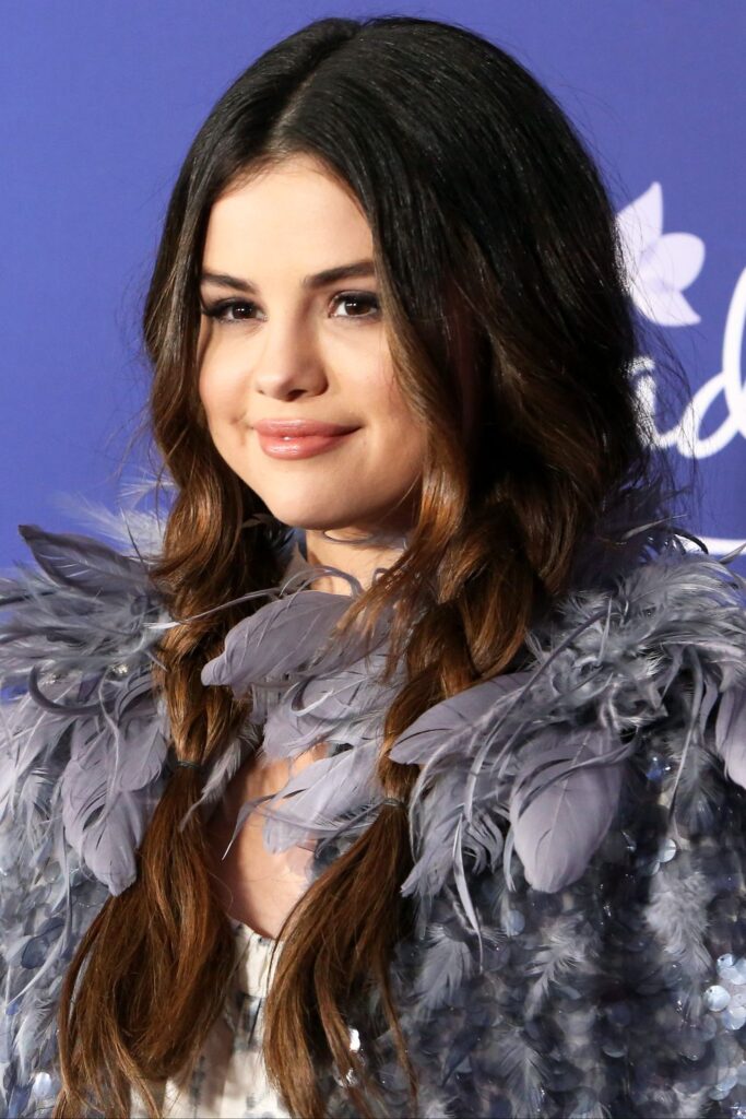 Selena Gomez in grey furry dress posing for camera and showing her Beachy Braids - Beachy Braids