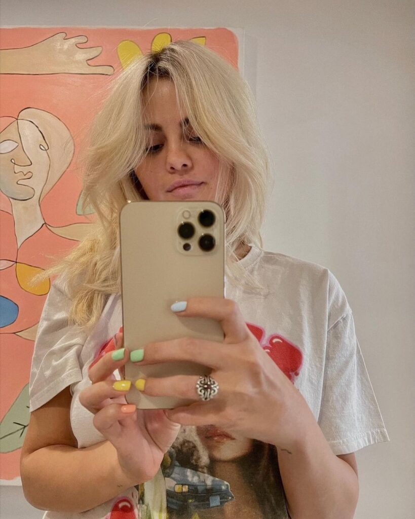 selena gomez in grey and red printed t-shirt posing for a selfie and showing her Platinum Blonde Locks - Selena Gomez Hairstyles
