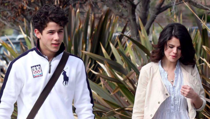 Selena Gomez in sky blue top with pink shrug and nick jonas in black and white sweat shirt posing for camera - selena gomez husband