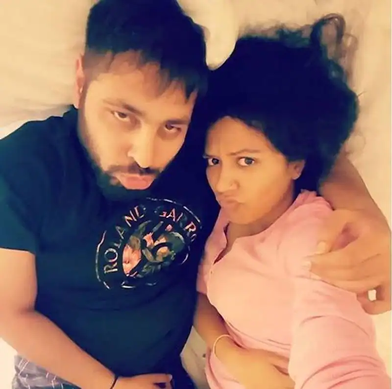 Badshah in blue t-shirt with wife Jasmine in pink top posing  for a selfie - bollywood singers with wife