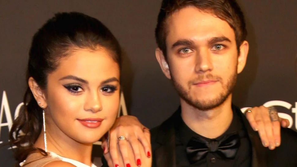 Selena Gomez in golden dress and Zedd in black suit with bow tie posing for camera - selena gomez and justin bieber