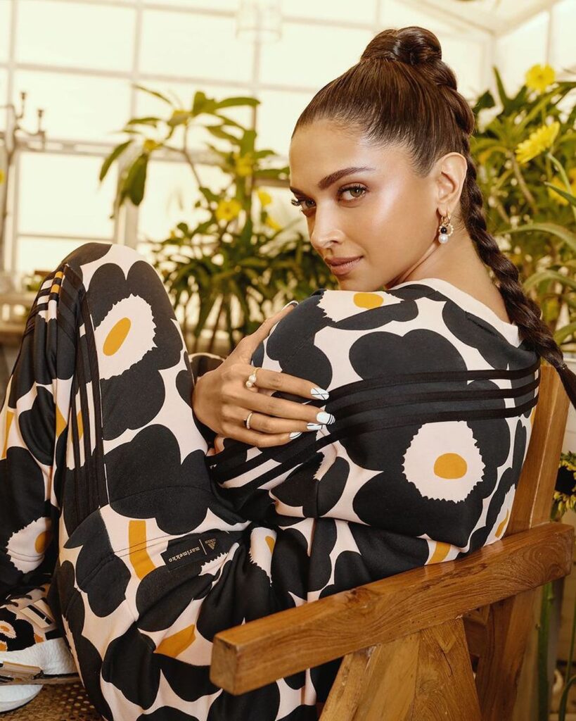 Deepika Padukone in Black and white dress sitting on a chair and showing her Braided High Ponytail - Deepika Padukone latest hairstyles