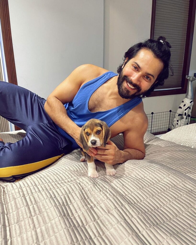 Varun Dhawan in lower and t-shirt with a half tie posing for camera along his puppy - bollywwod actors without makeup