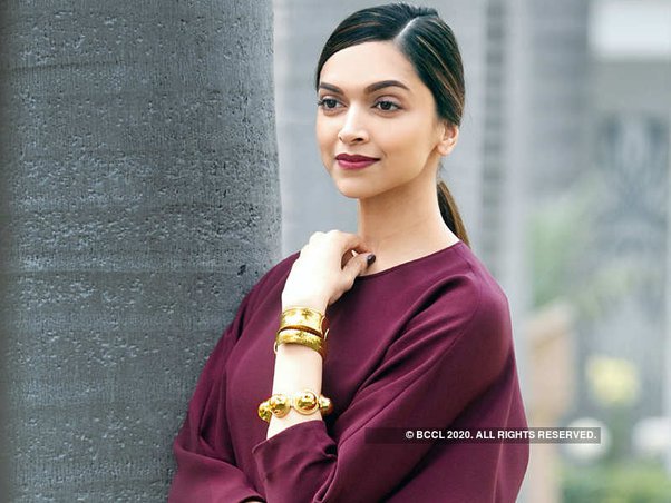 Deepika Padukone in purple dress with golden bracelet posing for camera and showing her Party type Get Straight hair - Deepika Padukone latest hairstyles