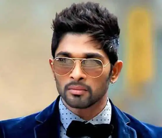 Allu Arjun in blue coat with white polka dotted shirt and bow tie and goggles posing for camera - Allu Arjun hairstyle photos