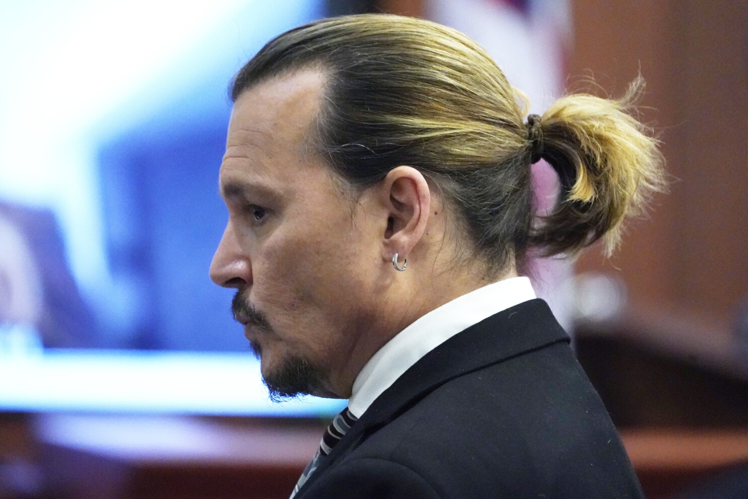 Johnny Depp in black coat with white shirt showing the side view of his ponytail - Johnny Depp latest hairstyles