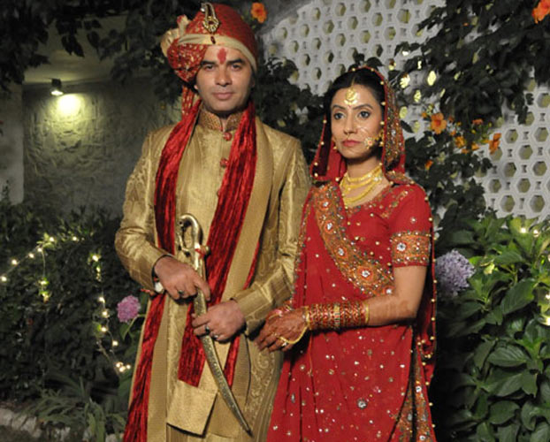 Mohit Chauhan in traditional groom outfit with his wife Prathna Gehlot in red lehenga - famous couple singers India
