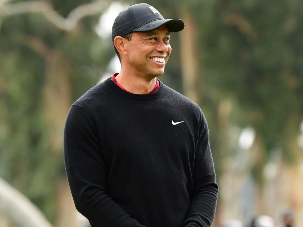 Smiling Tiger Woods in black t-shirt and cap - Famous people with lasik
